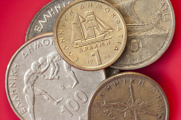 Assortment of Greek drachma coins with one drachma on top