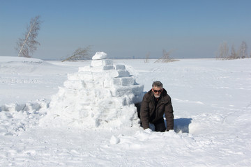 Man at the entrance to an igloo