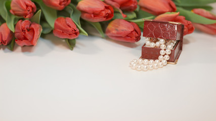 Red spring tulips with small box with pearls romantic present