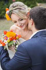 Young couple in wedding gown. Bride holding bouquet of flowers