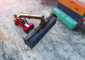 container stacker forklift working on lifting unit of container in yard in aerial view