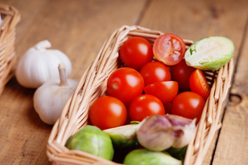 Wicker basket with vegetables on a wooden background 