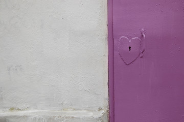.Door lock in the shape of a heart. Metal door. Wall. Background