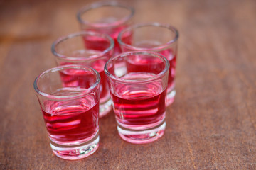 Shot with cranberry vodka on a wooden background