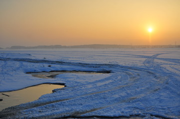 Landscape of sunset with smog, air pollution above frozen lake Pogoria in Dąbrowa Górnicza covered by snow. - obrazy, fototapety, plakaty