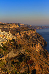Amazing sunset view with white houses in Oia village on Santorini island in Greece.
