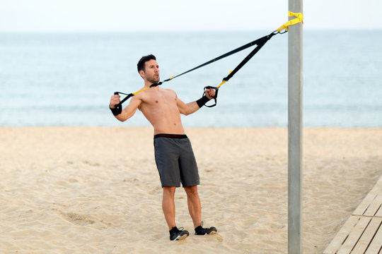 Athletischer Mann macht workout am Strand