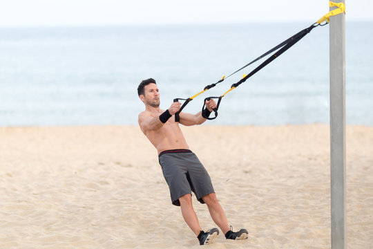 Athletischer Mann macht workout am Strand