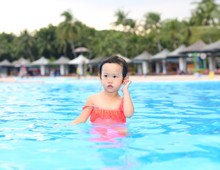 Fototapeta na wymiar Pretty little girl in swimming pool outdoors