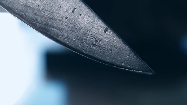 Steel knife blade. Close up of blade knife. Steel knife edge with water dripping. Water drop on steel knife blade