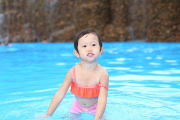 Fototapeta na wymiar Pretty little girl playing in swimming pool outdoors
