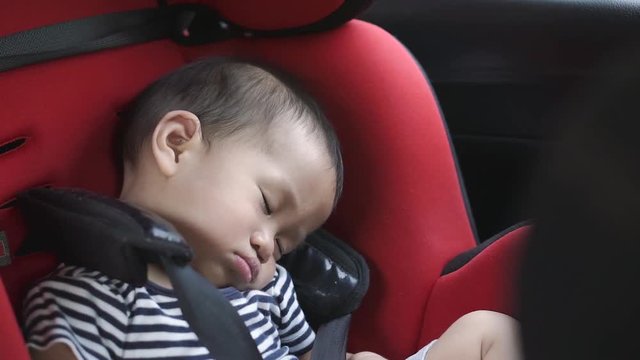 One year Asian baby sleeping in baby car seat