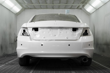 Auto body repair : White car in paint booth waiting for repaint