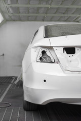 Auto body repair : Closeup of white car in paint booth