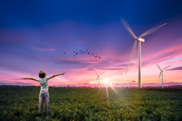 Petite fille devant un champs d'éoliennes