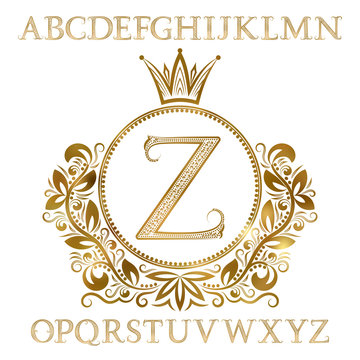 Golden patterned letters with initial monogram in coat of arms form. Shining font and elements kit for logo design.