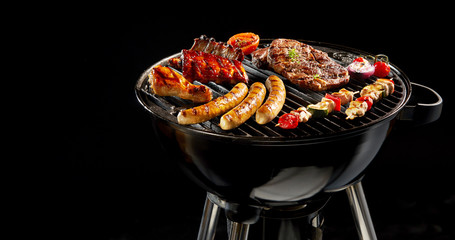 Variety of meat grilling on a portable barbecue