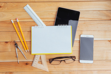 Top view of notebook, stationery, drawing tools and a few glasses. improvise.