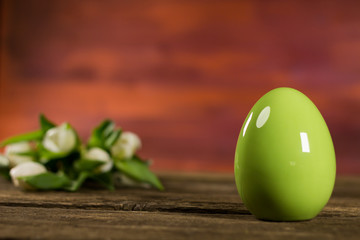 Easter theme. Eggs with tulips on wooden board, easter holiday concept. Copyspace for text.