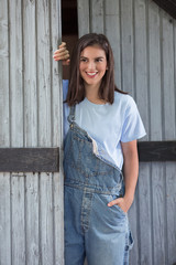 Portrait of modern young cowgirl in front of the barn