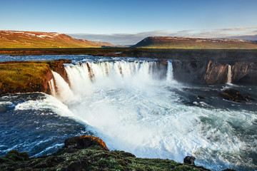 Godafoss waterfall at sunset. Fantastic landscape. Beautiful cumulus clouds. Iceland Europe