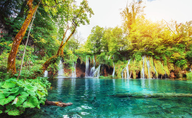 Waterfalls in national park falling into turquoise lake. Plitvice, Croatia