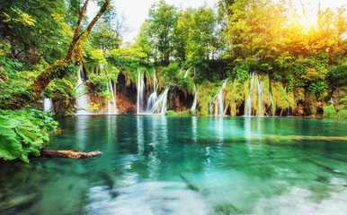 Waterfalls in national park falling into turquoise lake. Plitvice, Croatia