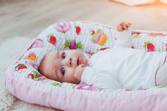 Photo charming newborn baby in a pink cradle