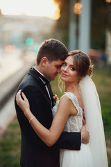 Bride hugs groom tender standing with him calmly on the lawn