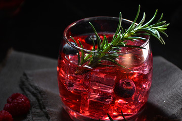 cocktail rosemary accompanied by raspberries