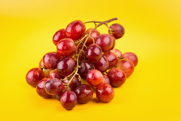 Fototapeta premium fresh and delicious red grapes isolated on yellow background