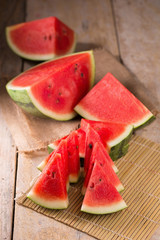 watermelon and watermelon pieces in a wooden background