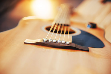 Photo fragment classical guitar on a light brown background.