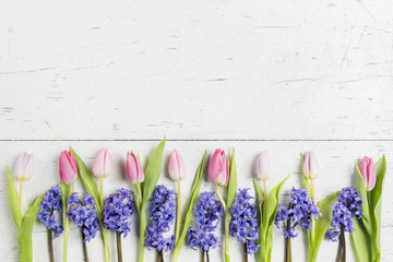 Beautiful pink tulips and hyacinths on white-plank background 
