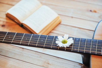 Close up classical guitar head with glasses and book