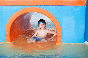 Sweet child, boy, playing in water world playground, enjoying attractions