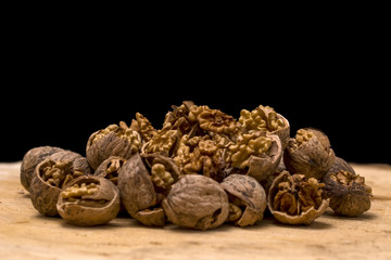 Walnut kernels and whole walnuts wood background