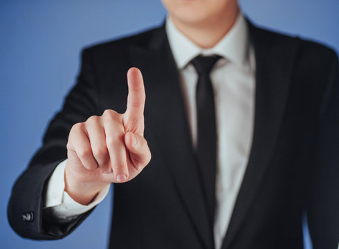 Businessman hand pointing on empty space on black background