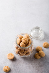 Amaretti cookies in glass pot on light gray background with copy space. High angle view