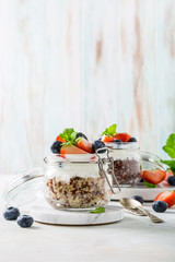 Quinoa with yogurt and berries in glass jar. Healthy gluten free breakfast concept with copy space.