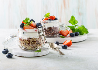 Gluten free breakfast with red quinoa, yogurt and berries in glass jar. Healthy super foods concept...