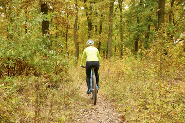 Obraz premium Female mountain biker. Rear view shot of a female cyclist out for a ride on her mountain bike in the forest.