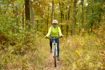 Female mountain biker. Rear view shot of a female cyclist out for a ride on her mountain bike in the forest.