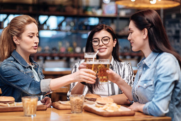 Company of girls clinking glasses