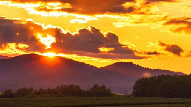 Biei Hill View The Patchwork Road sunset time lapse - Time lapse of the sun setting behind the field hill in biei hokkaido