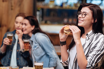 Cute brunette holding big burger