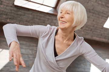 Positive aging woman learning step at the dance lesson