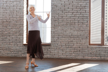 Positive senior woman performing at the dance lesson