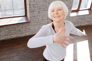 Charming elderly woman dancing at the ballroom