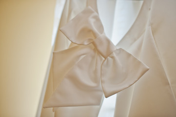 Bow of back of white wedding dress at light.